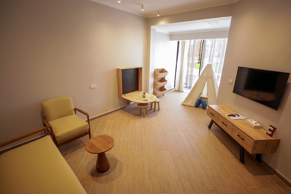 Helles, gemütliches Hotelzimmer mit zwei Doppelbetten, elegantem Mobiliar und Balkon mit Sitzgelegenheit.