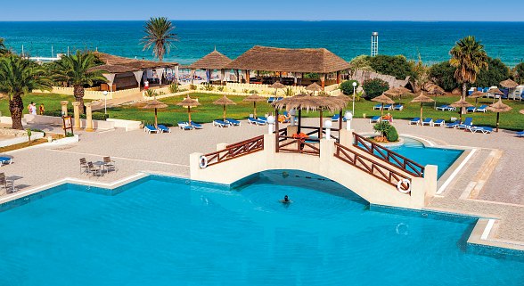 Bunte Wasserrutschen, die in einen großen Pool führen, umgeben von Palmen unter klarem Himmel.