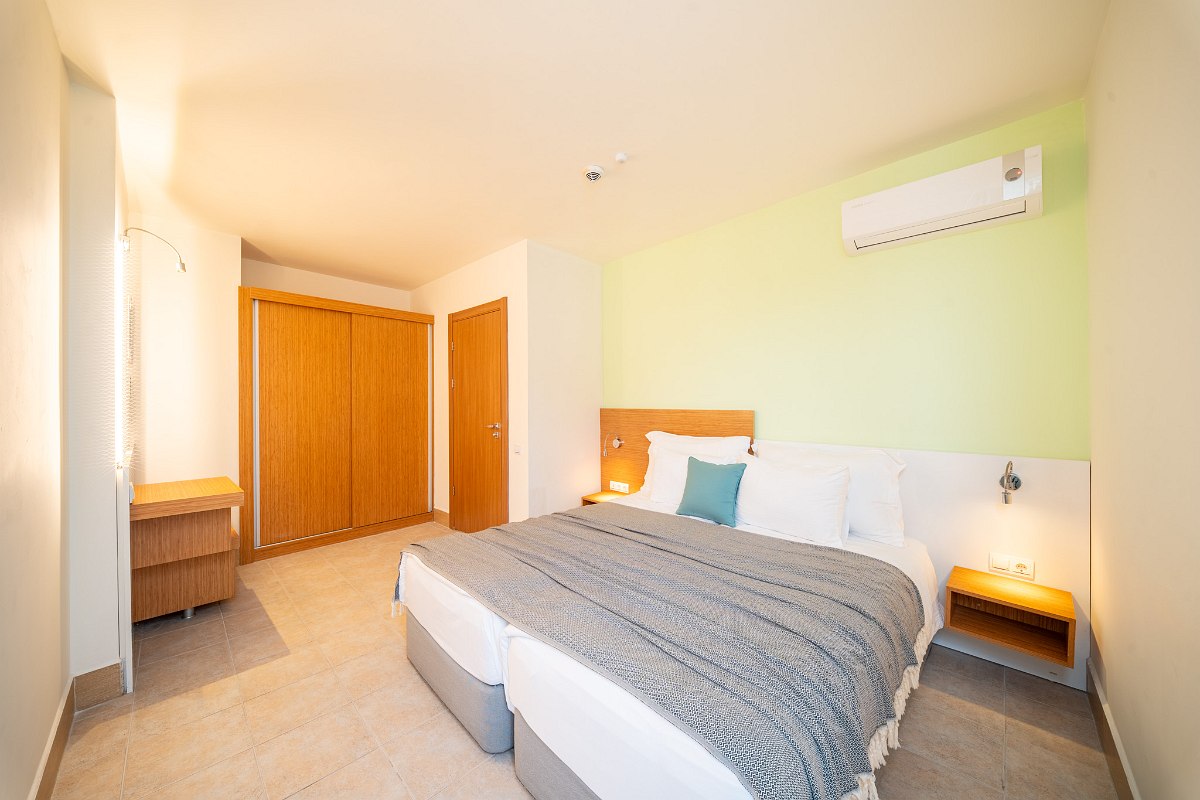 Hell eingerichtetes Zimmer mit zwei Einzelbetten, Sofa, Landblick, Wohnbereich und Schlafbereich, zwei Klimaanlagen, Nichtraucher Zimmer.