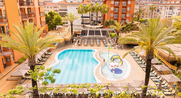 Blick auf Pool mit Liegen und Sonnenschirmen