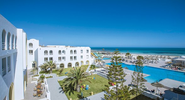 Weitläufige Hotelanlage mit Poollandschaft, Palmen, Sonnenterrassen und Blick auf das Meer.