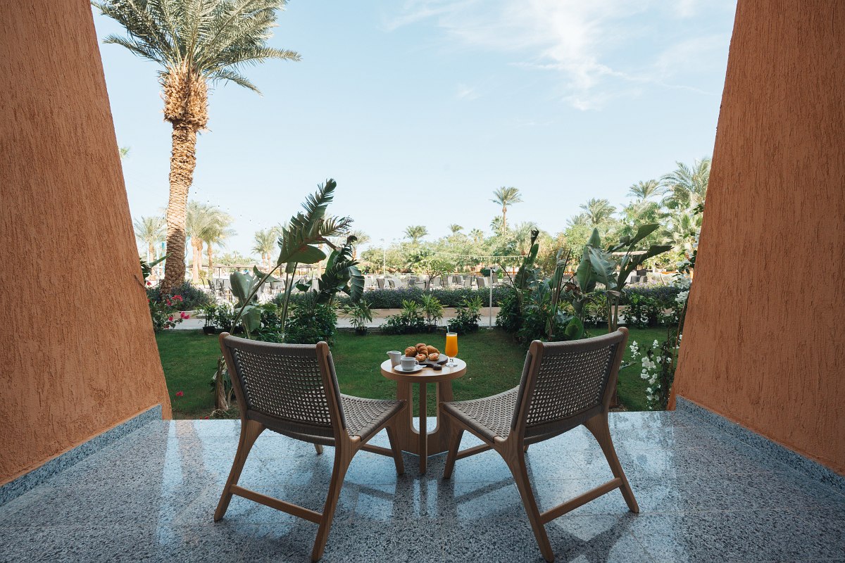 A marble bathroom with a large mirror, a countertop with a sink, a glass shower enclosure, and hanging pendant lights.