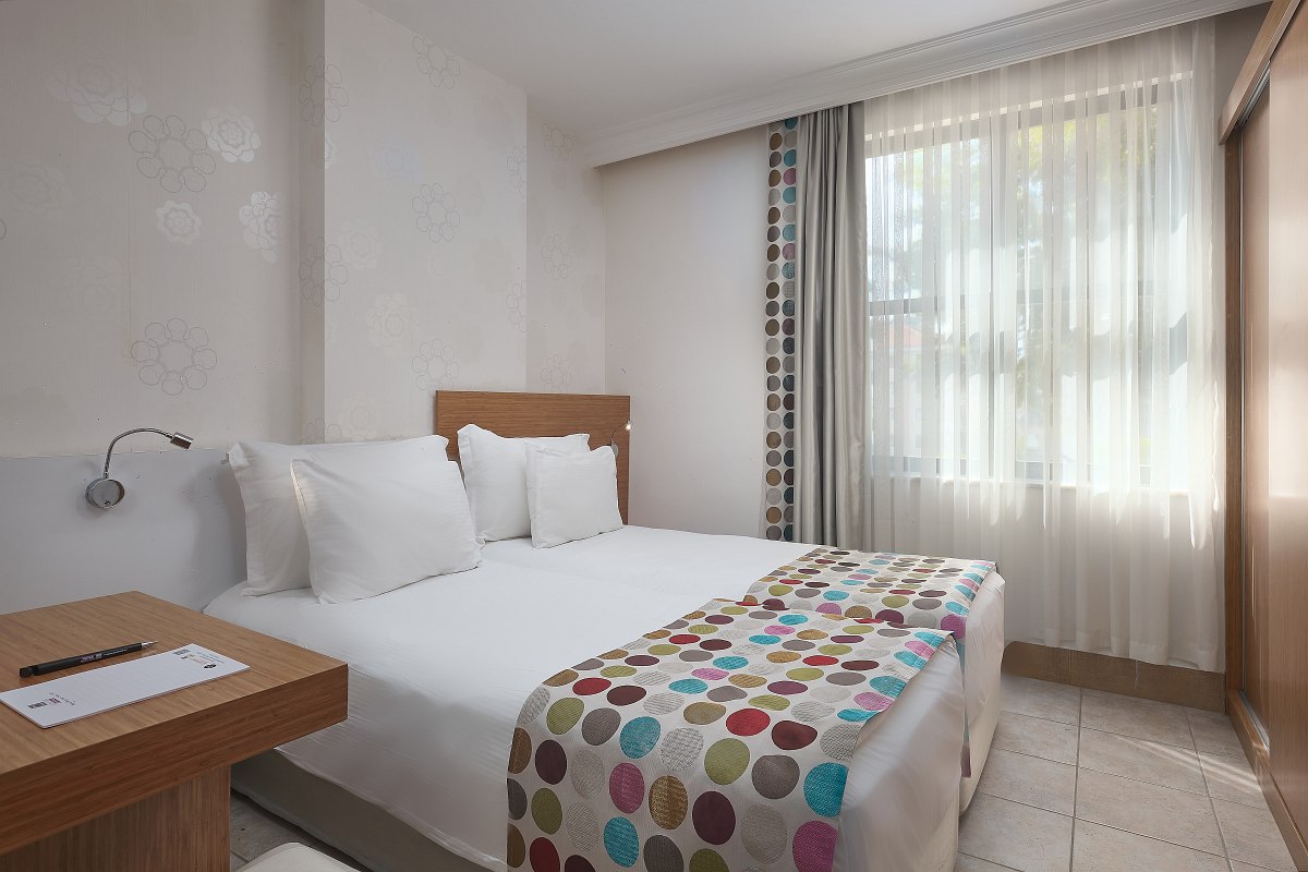 Modernes, hell eingerichtetes Zimmer mit zwei Betten, Fliesenboden, Klimaanlage, Landblick