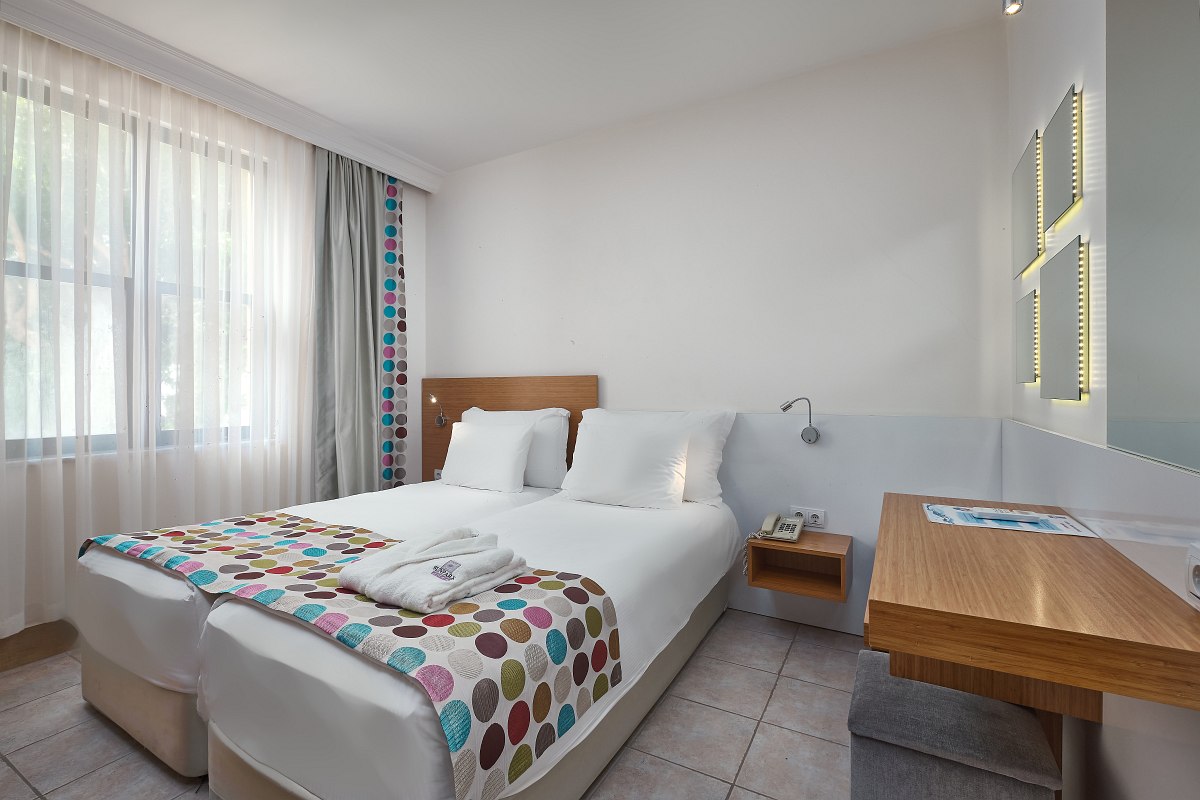 Modern eingerichtetes, helles Zimmer mit zwei Betten, Fliesenboden, Klimaanlage